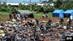 Personal cubano trabaja entre los escombros del avión accidentado en La Habana. 