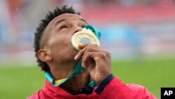 El cubano nacionalizado chileno Santiago Ford besa su medalla de oro durante la ceremonia de premiación del decatlón masculino en los Juegos Panamericanos en Santiago de Chile. (Foto AP/Silvia Izquierdo)