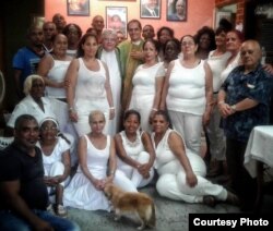 Damas de blanco y opositores se toman una foto con los padres José Conrado y Castor Álvarez luego de terminar la misa en la sede nacional de las Damas de Blanco. (Cortesía Angel Moya).