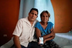 Alberto Betancourt y su madre Mayra Pérez posan con una foto de su hermana Daylin Betancourt, detenida por la policía durante una protesta, en La Habana, Cuba, el 19 de julio de 2021. Fotografía tomada el 19 de julio de 2021. REUTERS / Alexandre Meneghini