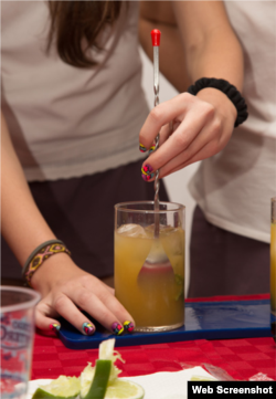 Una joven cubana prepara un trago.