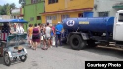 Vecinos de Santiago de las Vegas, en Boyeros hacen cola frente a una pipa de agua.