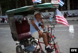 Un cubano exhibe una bandera de EEUU en su bicitaxi, en una calle de La Habana.