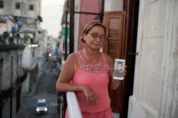 Raisa González reacciona mientras muestra una foto de su hijo Angelo Troya González, un artista sancionado tras protestas, en La Habana, Cuba, el 20 de julio de 2021. Fotografía tomada el 20 de julio de 2021. REUTERS / Alexandre Meneghini