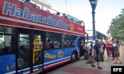 Turistas abordan un autobús turístico en La Habana.