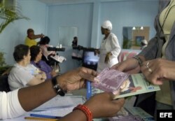 Una mujer cubana recibe un plegable, un condón y el folleto "Mujer y SIDA" .