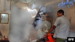 Un hombre fumiga una vivienda