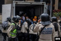 Agentes de la Policía Nacional Bolivariana detienen a manifestantes durante una marcha hacia la sede del Poder Electoral.