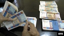 Una persona cuenta pesos cubanos convertibles.