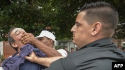 El periodista independiente Lázaro Yuri Valle Roca, siendo detenido el 10 de diciembre de 2015 en La Habana. Hoy, está confinado en el Combinado del Este, tras ser arrestado en junio del 2021. (Adalberto Roque/AFP).