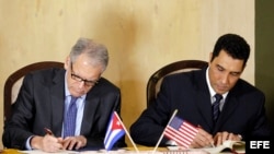 El embajador de EEUU en La Habana, Jeffrey DeLaurentis (i), y el viceministro de Transporte, Eduardo Rodríguez (d), firman el acuerdo de cooperación en La Habana.