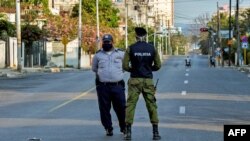 Oficiales de policía vigilan la entrada a un barrio del Vedado, en La Habana, cerrado por el coronavirus. 