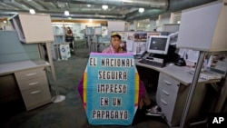 Un hombre sostiene un papayo (cometa) con un mensaje de apoyo al periódico El Nacional (AP Photo/Fernando Llano).