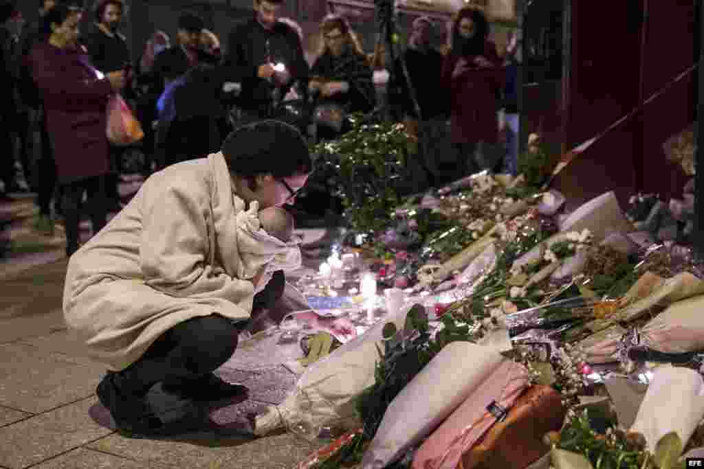 Una mujer rinde tributo a las víctimas frente al café Carillon, uno de los seis sitios atacados por los terroristas de Estado Islámico en París. EFE