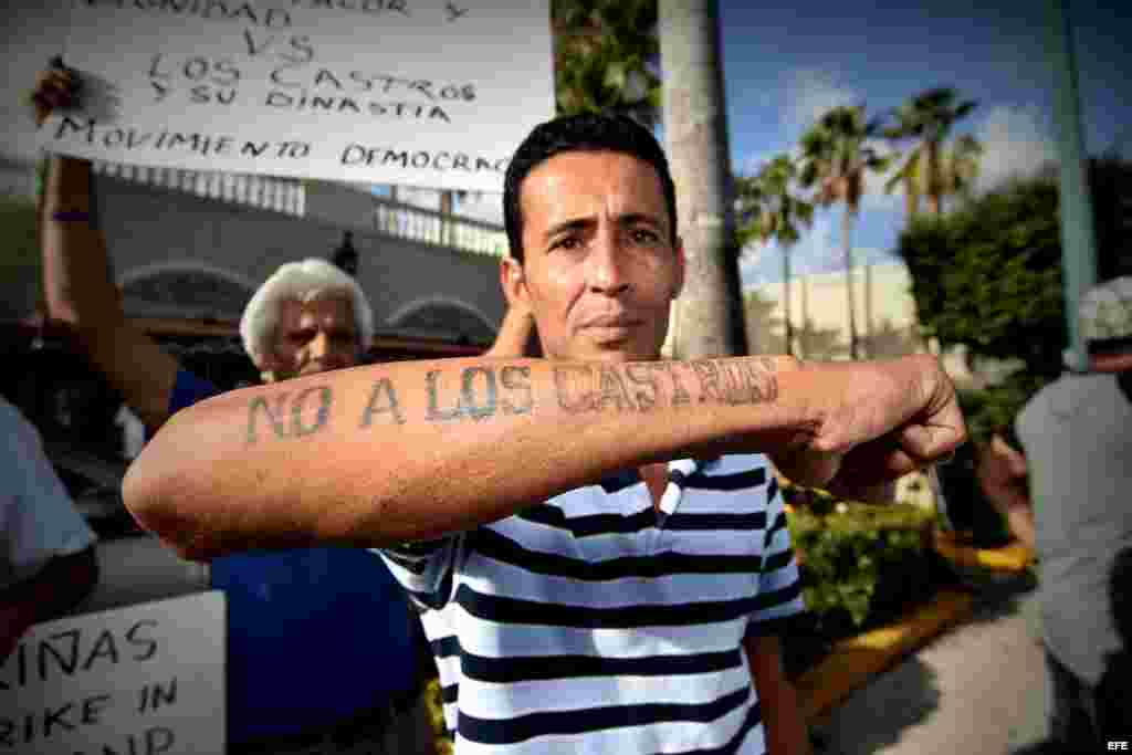 El cubano Alexander Otero muestra un tatuaje que dice "No a los Castros" durante una vigilia realizada hoy, miércoles 27 de julio 2016, frente al Restaurante Versailles en Miami, Florida.