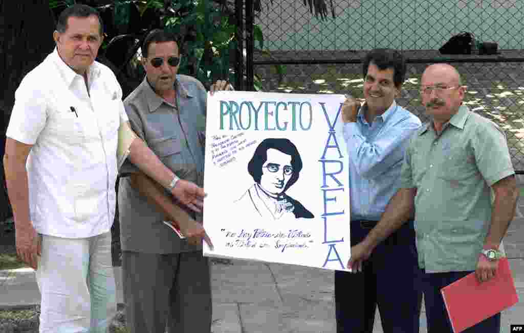 Hector Palacios (izq.) y Oswaldo Payá (2do der.), junto a otros disidentes, muestran una pancarta en alusión al proyecto Varela, momentos antes de su reunión con el ex presidente Jimmy Carter, en La Habana, el 16 de mayo de 2002.