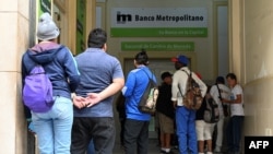 Los cubanos hacen cola frente a un banco en La Habana el 20 de diciembre de 2023. YAMIL LAGE / AFP