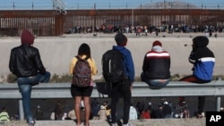 Migrantes observan el muro fronterizo en Ciudad Juárez, México, en diciembre de 2022, al otro lado de la frontera desde El Paso, Texas. AP/Christian Chávez