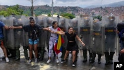 Residentes de un barrio de Caracas intentan bloquear una calle en protesta por los resultados de las elecciones en Venezuela que dan como ganador a Nicolás Maduro. (AP/Fernando Vergara)