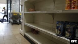 Un hombre ingresa a un supermercado con estanterías desabastecidas febrero de 2013, en Caracas (Venezuela). los ciudadanos se afanan en la búsqueda de pollo, harina, leche o azúcar.