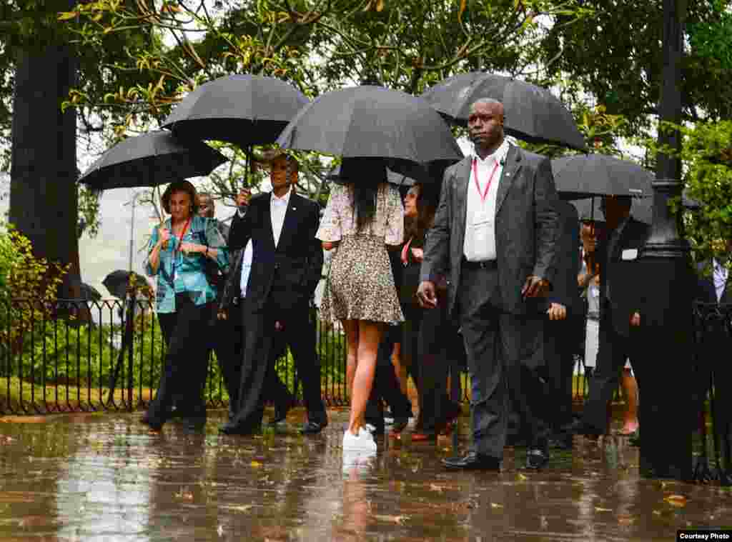 Obama y su familia recorriendo La Habana Vieja bajo la lluvia. 