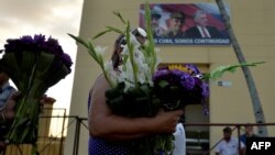 Una mujer lleva flores a San Lázaro en El Rincón, La Habana (Foto: Yamil Lage/AFP).