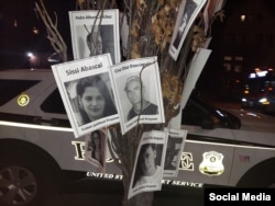 Fotos con el rostro de los presos politicos cubanos cuelgan de un árbol frente a la embajada de Cuba en Washington.