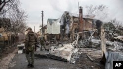 Un soldado ucraniano camina entre los restos de un avión derribado en Kyiv, Ucrania. (AP/Oleksandr Ratushniak).