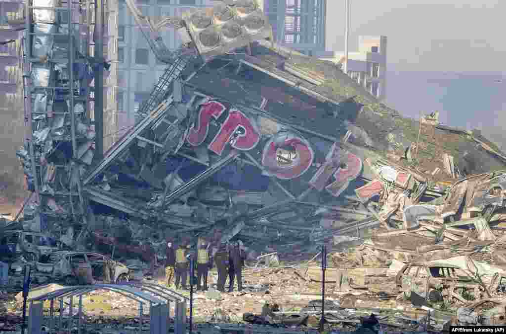 Personas evaluan el daño causado por un bombardeo ruso en un centro comercial, en Kyiv, Ucrania. Foto: AP/Efrem Lukatsky.