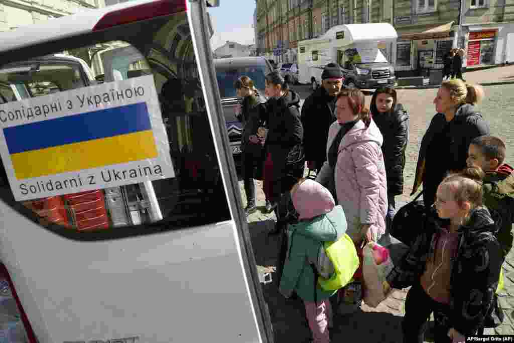 Refugiados ucranianos acompañados de niños se suben a un tren en una estación en Przemysl, Polonia. Foto: AP/Sergei Grits.