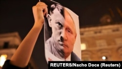 Una recreación de los rostros de Putin y Hitler en una protesta en Barcelona, España, contra la invasión a Ucrania.