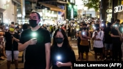 Residentes de Hong Kong rinden homenaje a los muertos de Tiananmén, el 4 de junio de 2021. (Isaac Lawrence / AFP).