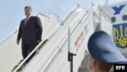 El presidente ucraniano, Petro Poroshenko (i), baja del avión a su llegada al aeropuerto nacional de Minsk (Bielorrusia), el martes 26 de agosto de 2014. 