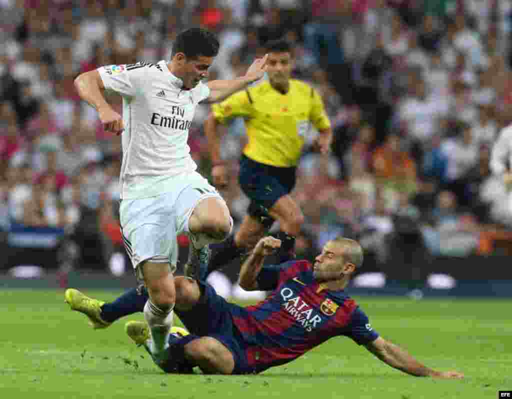 El defensa argentino del FC Barcelona Javier Mascherano (d) lucha un balón con el centrocampista colombiano del Real Madrid James Rodríguez (i). 