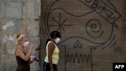 Dos mujeres caminan el martes por una calle de La Habana usando máscaras para evitar la propagación del coronavirus (Foto: Yamil Lage/AFP).