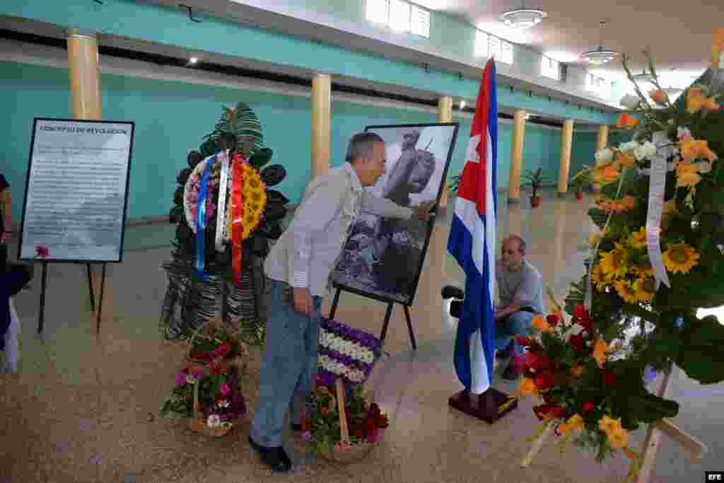 Un hombre rinde homenaje ante la foto como combatiene del líder cubano Fidel Castro.