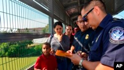 Funcionarios de Frontera procesan a una familia cubana en el Puente Internacional de Nuevo Laredo, Texas el 10 de julio de 2019. Foto AP /Salvador Gonzalez