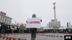 Un niño sostiene un cartel con el lema 'Yo soy Mariupol" en una manifestación por las víctimas del bombardeo de un autobús civil en Volnovaja.