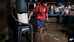 Una mujer revisa sus pertenencias en una vivienda inundada tras el paso de Iota, en Siuna, Nicaragua. (AP Photo/Carlos Herrera)