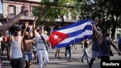 Manifestantes sostienen una bandera cubana durante las protestas del 11 de julio, en La Habana, Cuba. (REUTERS/Alexandre Meneghini)