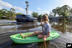 Halle Brooks navega en kayak por una calle inundada por el huracán Helene en el vecindario de Shore Acres el viernes 27 de septiembre de 2024 en San Petersburgo, Florida. (Foto AP/Mike Carlson)