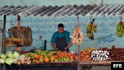 Un hombre vende frutas y verduras en un mercado agropecuario