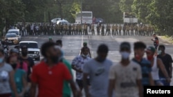 Manifestantes se alejan de los oficiales del MININT que bloquean una calle durante la protesta del 11 de julio en La Habana. (REUTERS/Alexandre Meneghini)