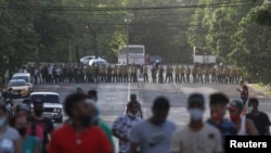 Manifestantes se alejan de los oficiales del MININT que bloquean una calle durante la protesta del 11 de julio de 2021 en La Habana. (REUTERS/Alexandre Meneghini).