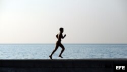 Un joven corre por el muro del malecón de La Habana.