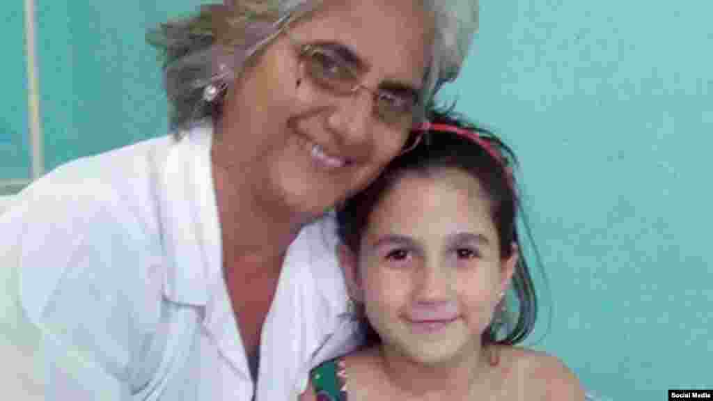 La niña posa junto a su psicóloga en el hospital pediátrico de Sancti Spíritus