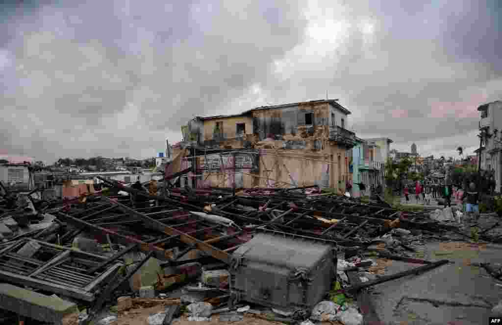 Habaneros caminan entre los escombros de sus casas destruidas tras el paso de un poderoso tornado que azotó la capital. 