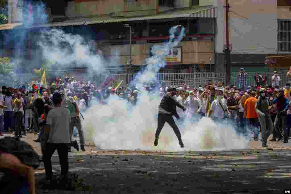 Un grupo de manifestantes se enfrenta con la policía durante una protesta en contra del Gobierno venezolano