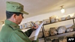 En esta foto de archivo tomada en 2005 un oficial cubano registra un cargamento de drogas incautado en Holguín.