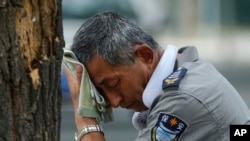 Un empleado intenta refrescarse el 3 de julio de 2023 en Pekín, China, donde las temperaturas batían récords. (AP Photo/Andy Wong)